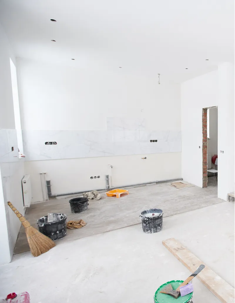 Unfinished, under renovation with construction tools, exposed wiring, and partially installed marble-patterned tiles.