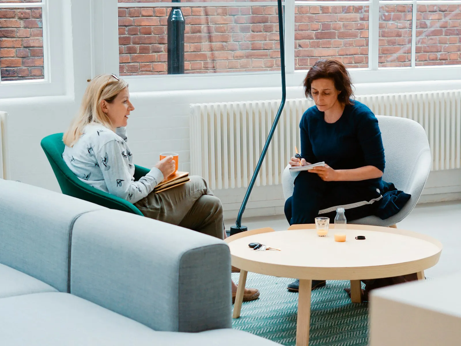 Two women sitting and talking about interior design.